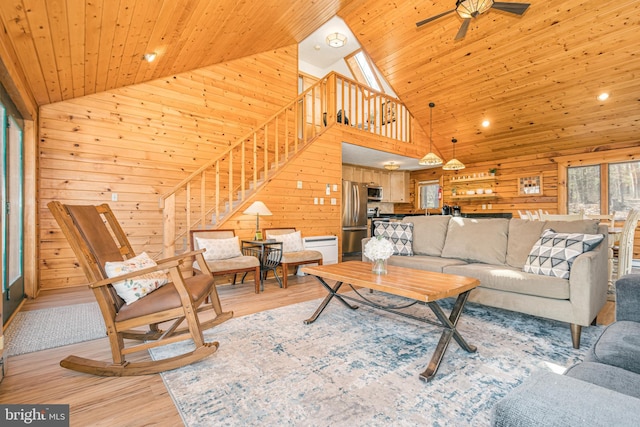 living room with light wood-style floors, wooden ceiling, and wooden walls