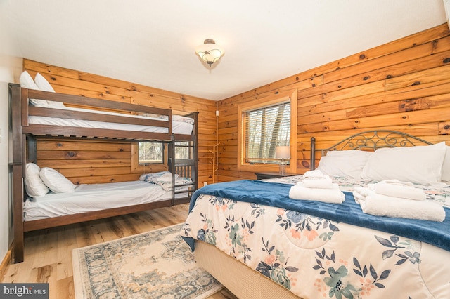 bedroom featuring wooden walls and wood finished floors