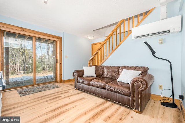 living room with stairs, baseboards, wood finished floors, and a wall mounted air conditioner