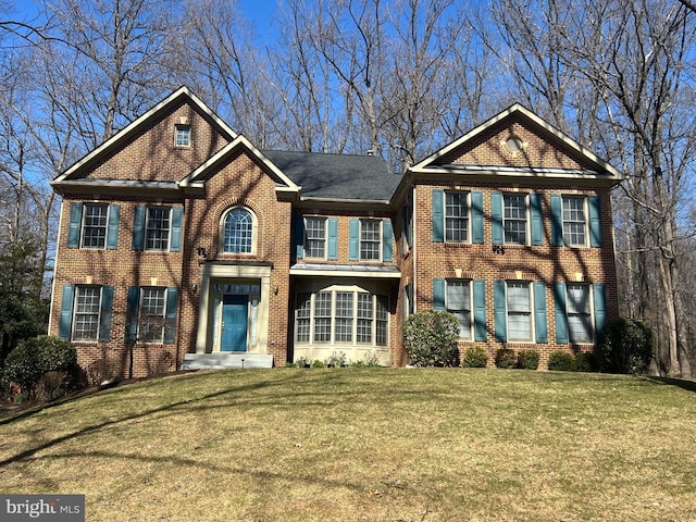 view of front facade featuring brick siding and a front lawn