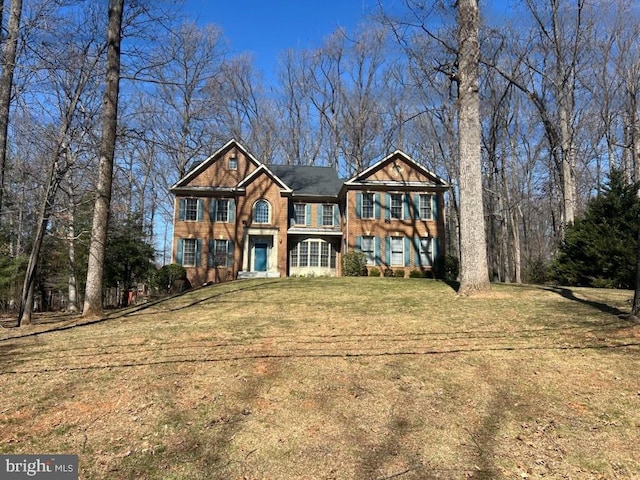 view of front of home featuring brick siding and a front lawn