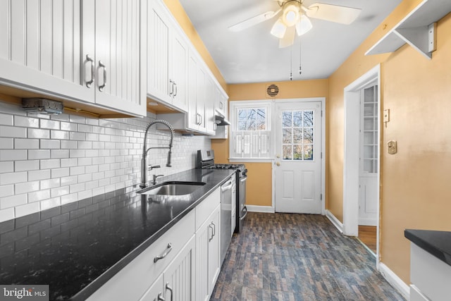 kitchen with baseboards, a sink, white cabinets, appliances with stainless steel finishes, and tasteful backsplash