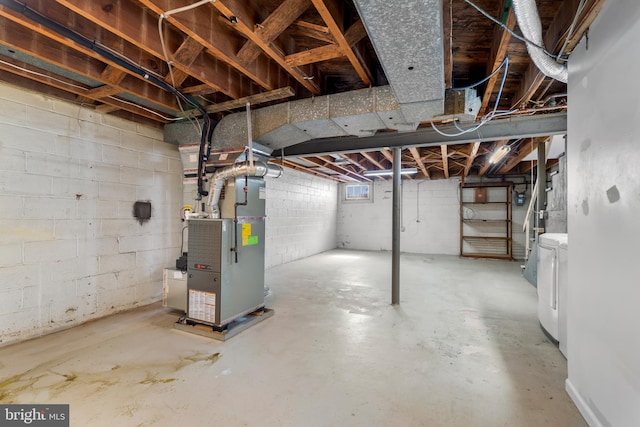 below grade area featuring heating unit and washer and clothes dryer