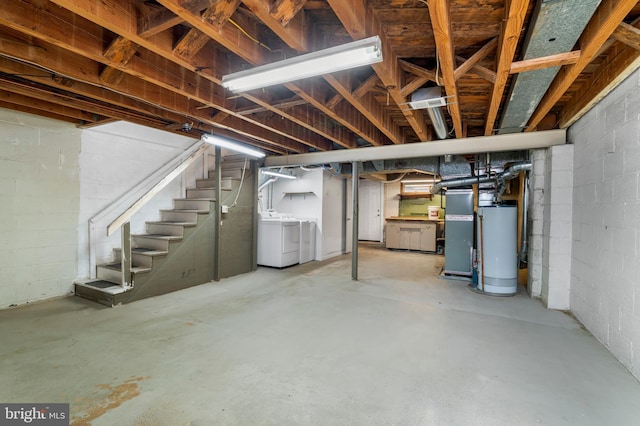 unfinished basement with heating unit, stairway, washer and dryer, and gas water heater