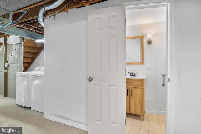 washroom featuring laundry area, washing machine and dryer, and a sink