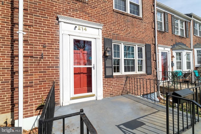 view of exterior entry featuring brick siding