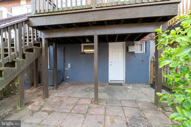 entrance to property featuring central air condition unit and a patio