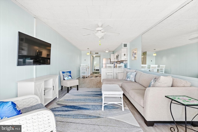 living area featuring wood finished floors and a ceiling fan