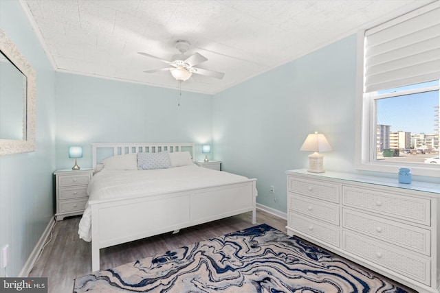 bedroom with a ceiling fan, baseboards, and wood finished floors