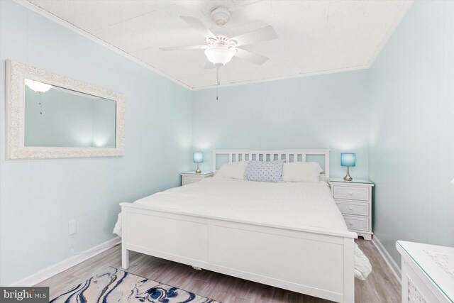 bedroom featuring a ceiling fan, baseboards, and wood finished floors