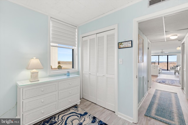 bedroom featuring light wood-style floors, a closet, multiple windows, and visible vents