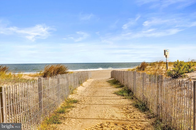 view of water feature with fence and a view of the beach