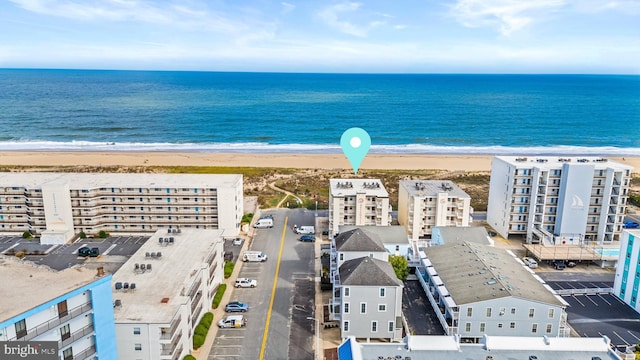 bird's eye view featuring a water view and a beach view