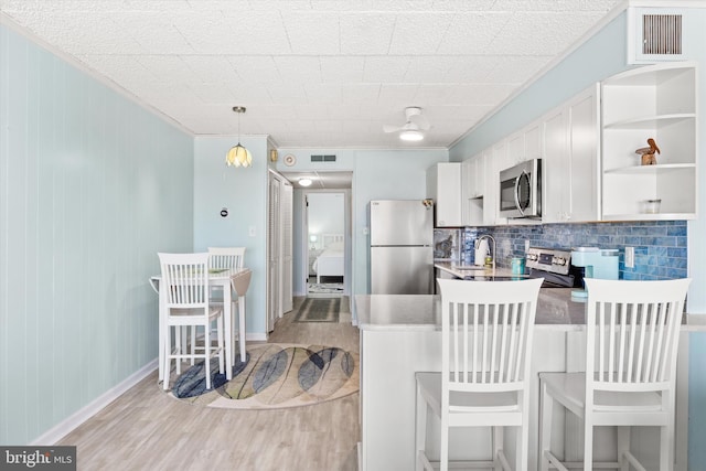 kitchen featuring appliances with stainless steel finishes, visible vents, light wood finished floors, and open shelves