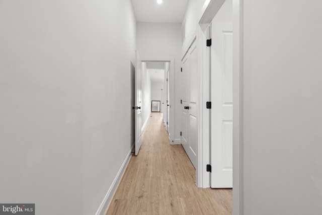 corridor featuring baseboards and light wood-style floors