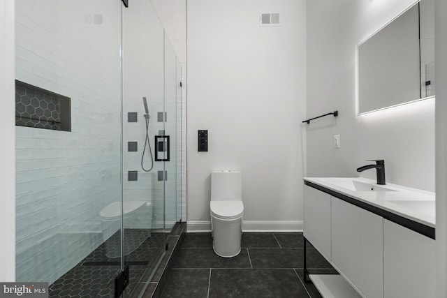 bathroom with tile patterned floors, toilet, a stall shower, a sink, and baseboards