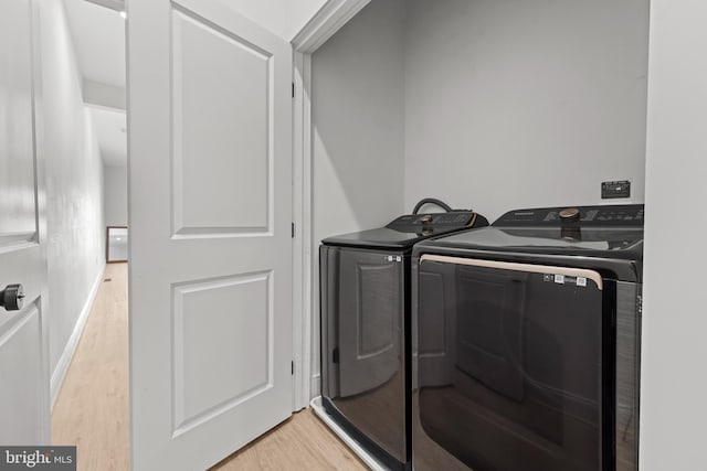 laundry room featuring light wood-style floors, separate washer and dryer, and laundry area