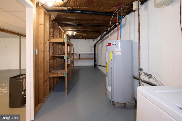 unfinished below grade area with water heater, washer / dryer, and concrete block wall