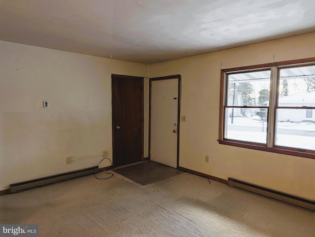 carpeted spare room featuring baseboards and baseboard heating