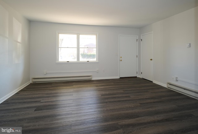 unfurnished room featuring baseboards, baseboard heating, and dark wood finished floors