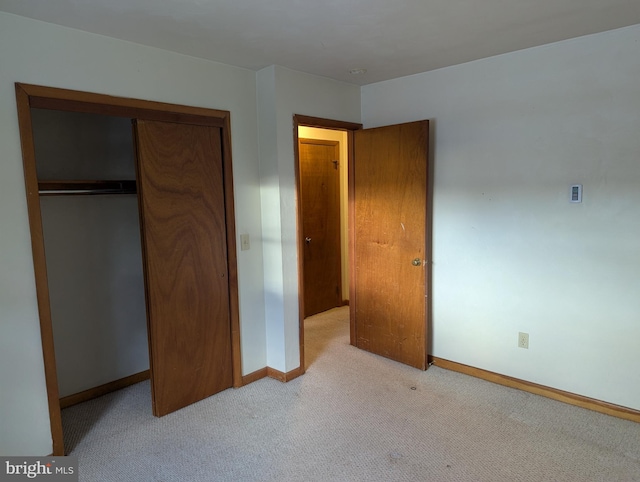 unfurnished bedroom featuring carpet floors, a closet, and baseboards