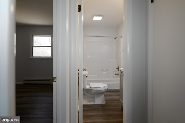 full bathroom featuring toilet, a baseboard heating unit, wood finished floors, and shower / bathtub combination