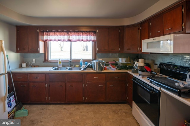 kitchen with a sink, white appliances, tasteful backsplash, and light countertops