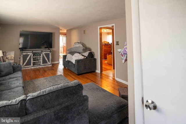 living area featuring baseboards and wood finished floors