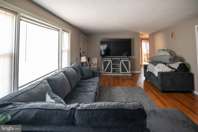 living room with visible vents, wood finished floors, and baseboards