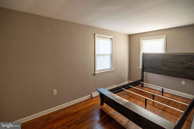 bedroom with hardwood / wood-style flooring and baseboards