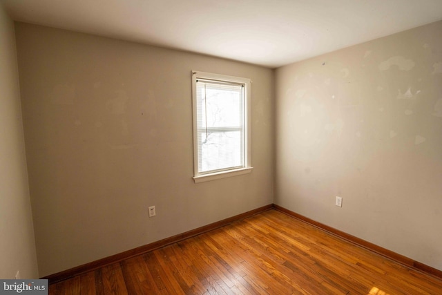 unfurnished room featuring baseboards and light wood finished floors