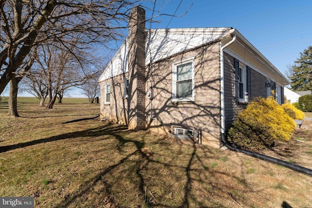 view of property exterior with a yard and a chimney