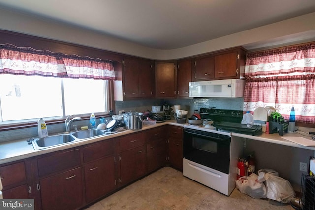 kitchen featuring a sink, electric range, white microwave, and light countertops