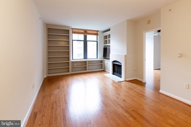 unfurnished living room featuring a fireplace, light wood-style flooring, and baseboards