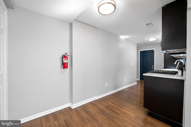 kitchen with light countertops, dark wood-style flooring, visible vents, and baseboards