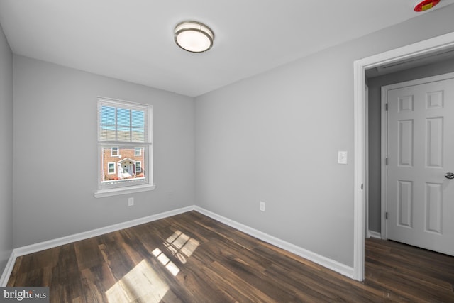 empty room with dark wood-style floors and baseboards