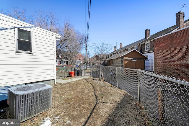 view of yard featuring central AC unit and fence