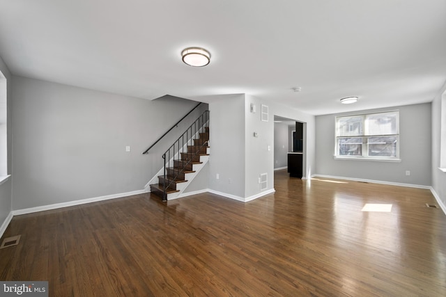 unfurnished living room featuring stairs, wood finished floors, and visible vents