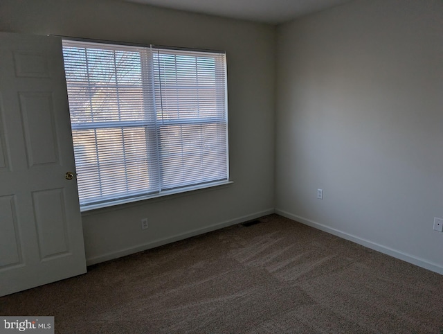 unfurnished room featuring carpet flooring, visible vents, and baseboards