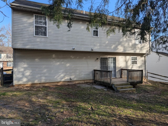 back of property with a lawn and a deck