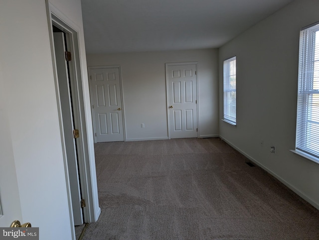 unfurnished bedroom featuring visible vents, baseboards, and carpet flooring