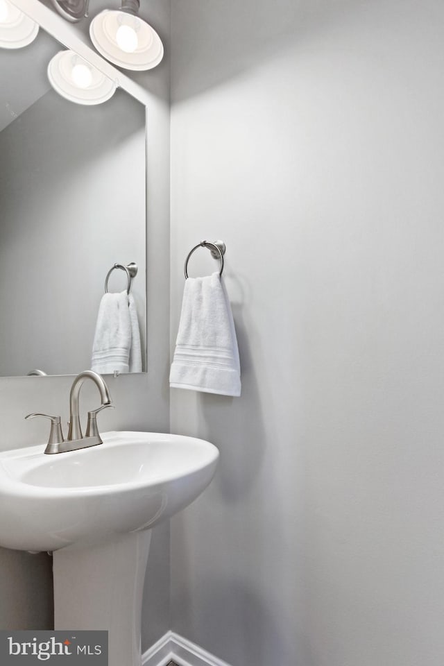 bathroom with a sink and baseboards