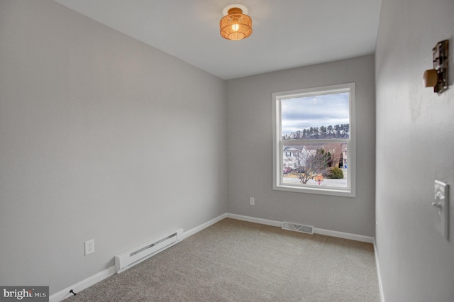 spare room featuring carpet floors, a baseboard radiator, visible vents, and baseboards