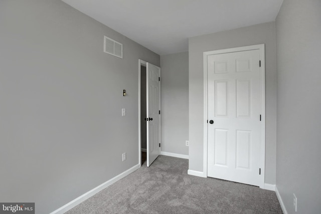 unfurnished bedroom featuring carpet, baseboards, and visible vents