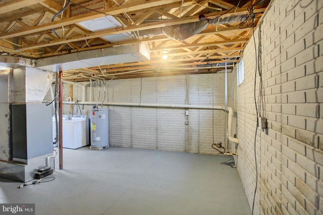 unfinished below grade area featuring water heater, brick wall, washer / clothes dryer, and heating unit