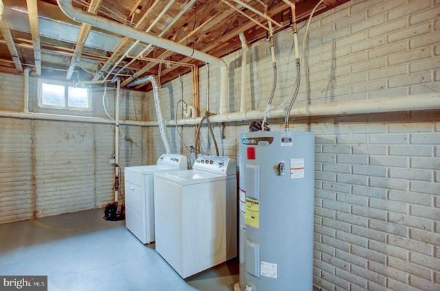 laundry room with laundry area, brick wall, water heater, and independent washer and dryer