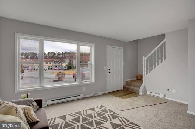 carpeted entrance foyer with a baseboard heating unit, visible vents, baseboards, and stairs