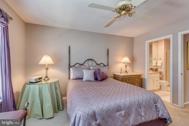 bedroom with light carpet, baseboards, a ceiling fan, and connected bathroom