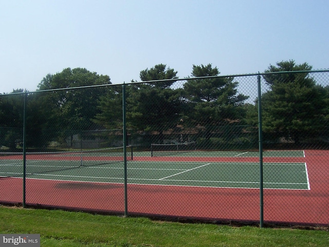 view of tennis court featuring fence