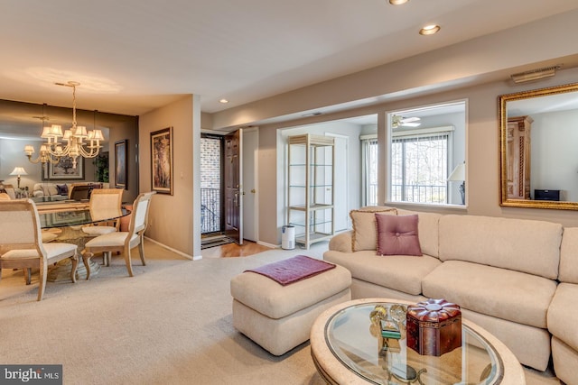 living area with carpet floors, a notable chandelier, recessed lighting, visible vents, and baseboards